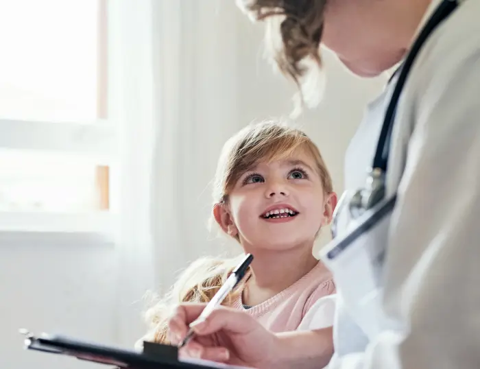 A photo of a little girl talking to a clinician.