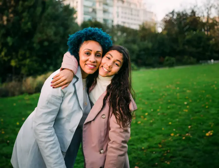 A photo of two people hugging in a park.