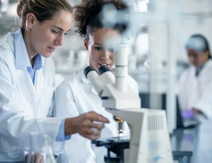A photo of scientists working with a microscope.